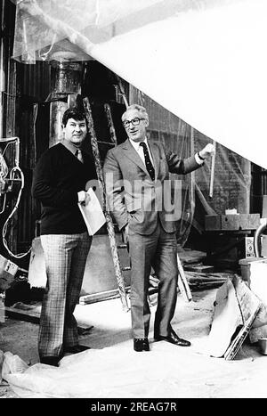 AJAXNETPHOTO. 25TH. MÄRZ 1975. PORTCHESTER, ENGLAND - WORLD GIRDLING YACHTSMAN CHAY BLYTH (GBR) (LINKS) MIT SEINEM SPONSOR „UNION“ JACK HAYWARD, DER DIE BAUKOSTEN VON £120.000 FÜR BLYTHS NEUEN 80FT GLASS FIBRE TRIMARAN GREAT BRITAIN III IN DER BAUSTELLE WICORMARINE ÜBERNIMMT. ES WAR HAYWARDS ERSTER BESUCH, UM DIE NEUE YACHT IM BAU ZU SEHEN. FOTO : JONATHAN EASTLAND / AJAX REF: 232404 952 Stockfoto