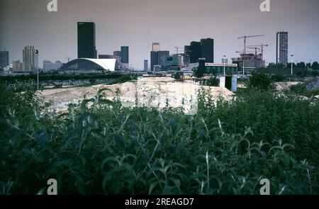 AJAXNETPHOTO. 2ND. NOVEMBER 1983. PARIS, NANTERRE, FRANKREICH - NIMMT GESTALT AN - BAUARBEITEN IM GESCHÄFTSVIERTEL VON LA DEFENSE LAUFEN. DAS ZENTRUM IST DIE ACHSE, AUF DER DIE LA-VERTEIDIGUNG „GRANDE ARCHE“ LETZTENDLICH GEBAUT WIRD, WOBEI DER ARC DE TRIOMPHE IM ZENTRUM VON PARIS NOCH SICHTBAR IST (ZENTRUM, FERNER HORIZONT). AUF DIESEM BILD. DER FRIEDHOF VON NEUILLY IST LINKS ZU SEHEN. FOTO: JONATHAN EASTLAND/AJAX REF: 842164 121 Stockfoto