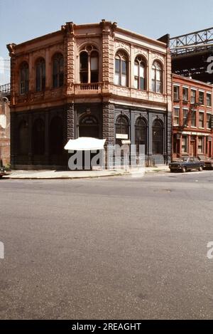 AJAXNETPHOTO. JULI 1975. BROOKLYN, NEW YORK, USA. - OLD BANK - BROOKLYN BRIDGE TOWER, DER SICH HINTER GESCHÄFTSGEBÄUDEN AUS DEM 19. JAHRHUNDERT AN DER ECKE DER FRONT STREET UND DER CADMAN PLAZA WEST ERHEBT; DIE ALTE FULTON FERRY BANK UND AUF DER LINKEN SEITE DAS ÄLTESTE VERBLEIBENDE KOMMERZIELLE GEBÄUDE AUS DEM 19TH. JAHRHUNDERT UNTER DEM DECK DER BROOKLYN BRIDGE, DIE DEN EAST RIVER ZWISCHEN PARK ROW MANHATTAN UND SANDS STREET, BROOKLYN, NEW YORK CITY, ÜBERSPANNT. FOTO: JONATHAN EASTLAND/AJAXREF:601874 137 2 Stockfoto