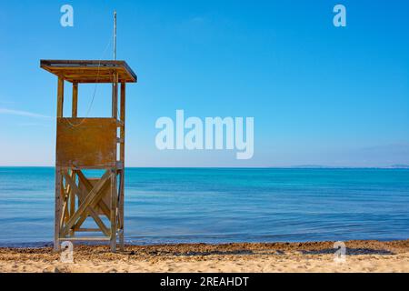 Rettungsschwimmturm an einem Sandstrand ohne Menschen, mit einem klaren blauen Himmel mit Blick auf das Mittelmeer. Stockfoto