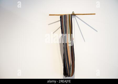 Gestreifter handgewebter Schal oder Teppich im Vintage-Stil, der an einem Holzbügel hängt Stockfoto