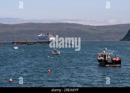 Portree, Insel von. Skye, Schottland, Großbritannien. 5. Juni 2023 Blick von Portree über den Hafen und kleine Boote zu einem Kreuzfahrtschiff vor Anker auf Loch Po Stockfoto