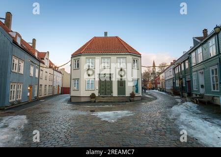 Nedre Baklandet Straße in Trondheim, Norwegen im Winter mit weihnachtsdekorationen vor blauem Himmel Stockfoto