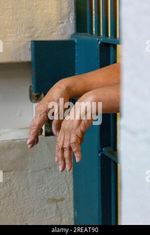 Hände hängen durch Gefängnisgitter. Stockfoto