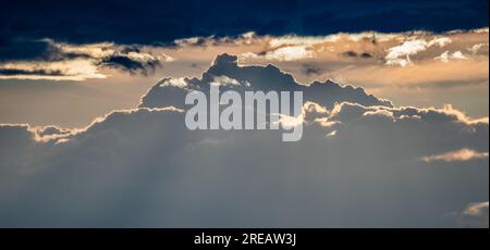 Wide Shot von rollenden Wolken mit Hintergrundbeleuchtung bei Sonnenuntergang über den Rocky Mountains Stockfoto