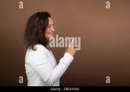 Porträt einer Coaching-Frau, die Handgesten macht. Konzept demokratischer und motivierender Manager. Isoliert auf braunem Hintergrund. Stockfoto