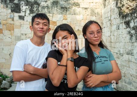 Oslob, Cebu, Philippinen-Januar 27 2023: Eine Pause vom Vloggen einer Tanzroutine, mit Ruinen als Ort, drei Freunde, lokale Teenager fragen nach Stockfoto