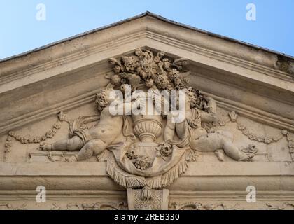 Montpellier, Frankreich - 07 23 2023 : Detailansicht eines klassischen Steintreppchens mit Cherubs um die Blumenvase auf einem antiken Gebäude im historischen Stadtzentrum Stockfoto