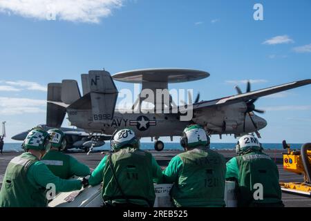 INDISCHER OZEAN (25. Juli 2023) Seeleute beobachten, wie ein E-2D Hawkeye, befestigt an den Tigerschwänzen der Airborne Early Warning Squadron (VAW) 125, auf dem Flugdeck der USA landet Der einzige Flugzeugträger der Navy, USS Ronald Reagan (CVN 76), während des Flugbetriebs zur Unterstützung von Talisman Sabre 23 im Indischen Ozean, am 25. Juli 2023. Ronald Reagan, das Flaggschiff der Carrier Strike Group 5, stellt eine kampfbereite Truppe bereit, die die Vereinigten Staaten schützt und verteidigt und Bündnisse, Partnerschaften und kollektive maritime Interessen in der Region Indo-Pazifik unterstützt. Talisman Sabre ist der Knaller Stockfoto