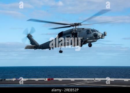 INDISCHER OZEAN (25. Juli 2023) ein MH-60R Sea Hawk, angeschlossen an die Saberhawks of Helicopter Maritime Strike Squadron (HSM) 77, landet auf dem Flugdeck der USA Der einzige Flugzeugträger der Navy, USS Ronald Reagan (CVN 76), während des Flugbetriebs zur Unterstützung von Talisman Sabre 23 im Indischen Ozean, am 25. Juli 2023. Ronald Reagan, das Flaggschiff der Carrier Strike Group 5, stellt eine kampfbereite Truppe bereit, die die Vereinigten Staaten schützt und verteidigt und Bündnisse, Partnerschaften und kollektive maritime Interessen in der Region Indo-Pazifik unterstützt. Talisman Sabre ist der größte bilaterale Stockfoto