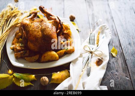 Herbstkomposition mit Blättern, reifem Kürbis und Thanksgiving-truthahn auf einem dunklen Holztisch. Stockfoto