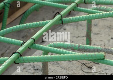 Epoxidbeschichteter Bewehrungsstahl wird in Beton verwendet, der korrosiven Bedingungen ausgesetzt ist. Dazu kann die Exposition gegenüber Enteisungssalzen oder Meeresumgebungen gehören. Stockfoto