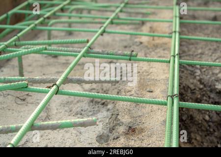 Epoxidbeschichteter Bewehrungsstahl wird in Beton verwendet, der korrosiven Bedingungen ausgesetzt ist. Dazu kann die Exposition gegenüber Enteisungssalzen oder Meeresumgebungen gehören. Stockfoto