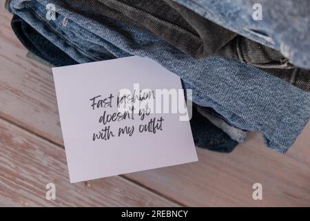 SCHNELLE MODE PASST NICHT ZU MEINEM OUTFIT Text auf Papier Zettel zu Jeans Bekleidung Sortiment Second Hand nachhaltiges Shopping. Kapsel-Minimalgarderobe. Nachhaltiger Überkonsum von Mode, bewusster Konsum, langsames Modekonzept. Abfallarmes Leben Stockfoto