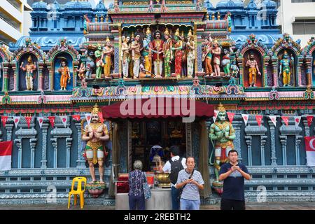 Zwei ethnische chinesische Männer beten vor dem reich verzierten Sri Krishnan Tempel, einem Hindu-Tempel im südindischen Stil in Waterloo St., Bugis, Singapur Stockfoto