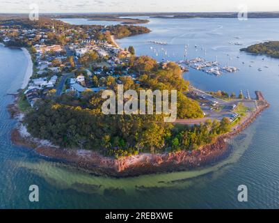 Luftaufnahme eines Felsenpunktes in einer Küstenbucht mit einem Yachthafen und einem Anwesen am Soldiers Point in New South Wales, Australien Stockfoto