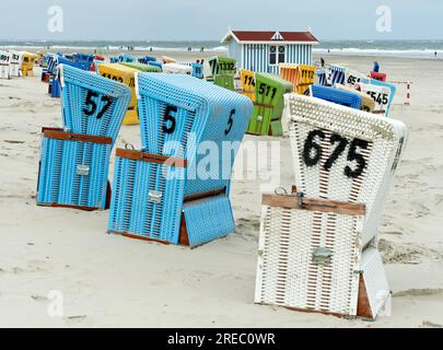 Bunte Liegestühle an einem kühlen Tag in der Vorsaison am Strand von Langeoog, Ostfriesische Inseln, Niedersachsen, Deutschland Stockfoto