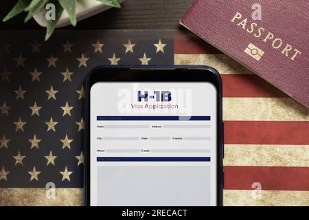 H-1b Visumantragskonzept: Smartphone mit USA H-1B Visumantrag über US-Flagge Stockfoto