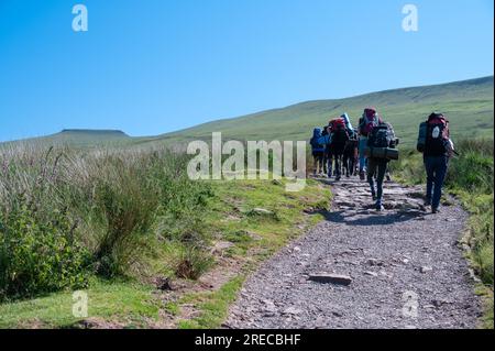 Walking Up Pen Y Fan vom Pont Ar DAF-Parkplatz mit Corn Du im Hintergrund, South Wales, Großbritannien. Stockfoto