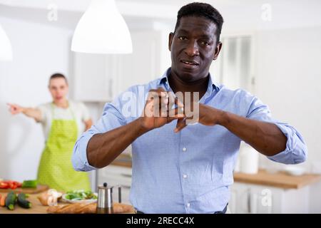 Mann, der während des Streits mit seiner Frau den Ehering auszieht Stockfoto