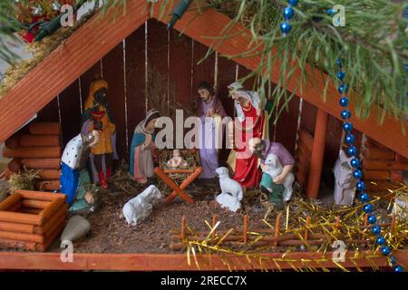 Die Geburt Jesu in der Krippe zwischen den Tieren in einem Holzhaus Stockfoto