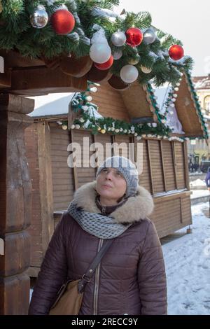Frau geht auf einem geschlossenen Weihnachtsmarkt auf dem Platz spazieren Stockfoto