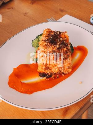 Gourmetgericht mit knusprigem Lachs mit getrocknetem Fruchtteig und Karottenpüree Stockfoto