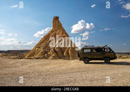 Spanien: Landschaft, halbwüste Naturregion der Bardenas Reales, Navarre. Roadtrip auf den Bardenas: Wohnmobil auf einer Feldbahn Stockfoto