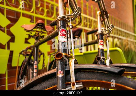 Zwei klassische Yongjiu-Fahrräder (für immer) an einem Fahrradständer vor dem Super Park Store in der Feng Sheng Li Gegend im Zentrum von Shanghai. Bezirk Jing’an, Stockfoto