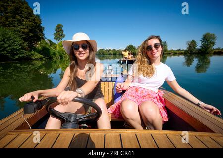 Elektroboot, Gruppe von Freunden auf einer Bootsfahrt auf dem Canal Charles Quint und dem Fluss Doubs in Dole (Nordostfrankreich). Zwei junge Frauen auf einer Boa Stockfoto