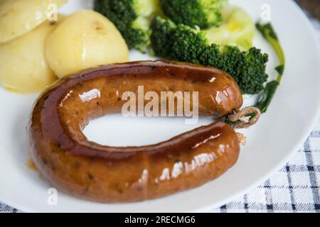 Alheira, ein typisches Gericht der portugiesischen Gastronomie aus Schweinefleisch mit Brokkoli und gekochten Kartoffeln, die mit Olivenöl getränkt werden. Typisches Essen und vieles mehr Stockfoto