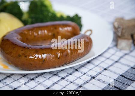 Alheira, ein typisches Gericht der portugiesischen Gastronomie aus Schweinefleisch mit Brokkoli und gekochten Kartoffeln, die mit Olivenöl getränkt werden. Typisches Essen und vieles mehr Stockfoto