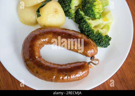 Alheira, ein typisches Gericht der portugiesischen Gastronomie aus Schweinefleisch mit Brokkoli und gekochten Kartoffeln, die mit Olivenöl getränkt werden. Typisches Essen und vieles mehr Stockfoto