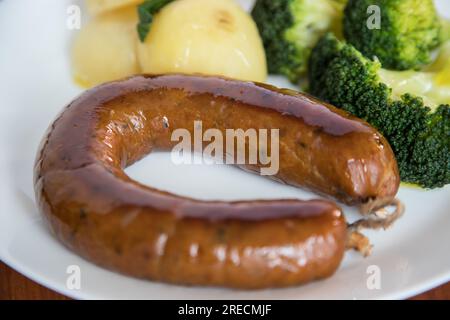 Alheira, ein typisches Gericht der portugiesischen Gastronomie aus Schweinefleisch mit Brokkoli und gekochten Kartoffeln, die mit Olivenöl getränkt werden. Typisches Essen und vieles mehr Stockfoto