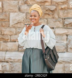 Handy, Spracherkennung und schwarze Frau in der Stadt, die mit einer Aktentasche in einer Stadtstraße spaziert. Technologie, Memo und afrikanische Designerin Stockfoto