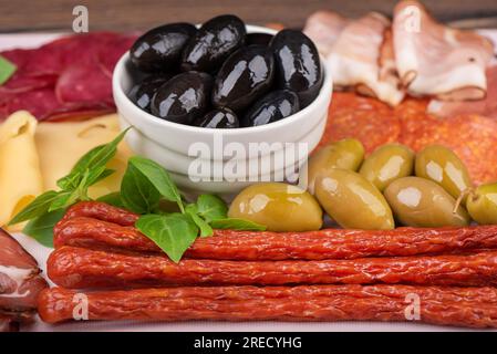 Weicher Fokus auf Vorspeisen aus geräucherten Würsten, Käse und Oliven. Gute Vorspeisen für Wein oder Bier. Schließen. Stockfoto