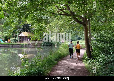 Rückblick zweier junger Läuferinnen auf dem Schleppweg am River Wey Navigation Kanal an einem Sommertag Weybridge Surrey England UK Stockfoto