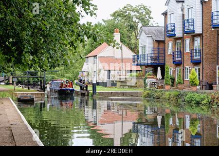 Ein kleines schmales Boot, das die Themse Lock auf dem River Wey Navigation Canal verlässt Weybridge Surrey England UK Stockfoto