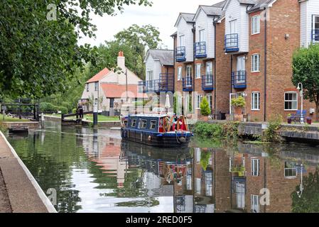 Ein kleines schmales Boot, das die Themse Lock auf dem River Wey Navigation Canal verlässt Weybridge Surrey England UK Stockfoto