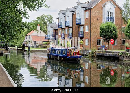 Ein kleines schmales Boot, das die Themse Lock auf dem River Wey Navigation Canal verlässt Weybridge Surrey England UK Stockfoto