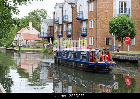 Ein kleines schmales Boot, das die Themse Lock auf dem River Wey Navigation Canal verlässt Weybridge Surrey England UK Stockfoto