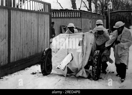 Soldaten der Waffen-SS schieben einen 3,7cm Pak 36 in Position. Waffe und Männer sind provisorisch getarnt mit weißem Tuch. Foto: Rauties. [Maschinelle Übersetzung] Stockfoto