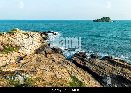 Malerische Meereslandschaft mit Felsformationen und steiniger Küste, die von blauen Wellen des türkisfarbenen Meeres vor wolkenlosem Himmel in der Natur gespült wird Stockfoto