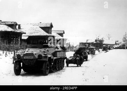 Deutsche Truppen, angeführt von einem SdKfz. 251 Uhr, Rollen Sie durch ein Dorf im mittleren Teil der Ostfront. Foto: Tannenberg. [Maschinelle Übersetzung] Stockfoto