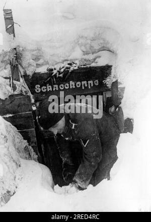 Ein deutscher Soldat schaufelt Schnee aus dem Eingangsbereich seines Heims. Foto: Rutkowski. [Maschinelle Übersetzung] Stockfoto