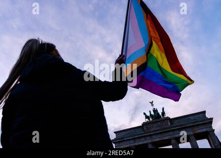 Deutschland, Berlin, 06. Dezember 2020: Die Silhouette einer Person mit einer Fortschrittsflagge kann als queere feministische Aktivistengruppen gegen patriarchales und repressives Verhalten am Pariser Platz vor dem Brandenburger Tor gesehen werden. Die Organisatoren wollen auf den zunehmenden Sexismus und häusliche Gewalt während der Quarantäne als Folge der weltweiten Covid-19-Pandemie aufmerksam machen und die aktuelle rechtliche Situation bezüglich Abtreibung in Polen und Deutschland kritisieren. Polens Verfassungsgericht, das von der national-populistischen Regierungspartei PiS kontrolliert wird, hat die aktuelle Abtreibung erklärt Stockfoto