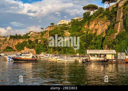 Boote, die in Marina Piccola vor Anker liegen und im goldenen Licht liegen, während die Sonne über der Bucht von Neapel in Sorrent in der Region Kampanien im Südwesten Italiens untergeht Stockfoto