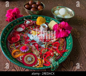 Dekorierter Pamoja- oder Thallium-Thallium mit Reiskörnern, Kumkum, Ladoo, Gulab-Jamun, Raki, Blume und Diya für Rakhi oder raksha bandhan Festival in Indien Stockfoto