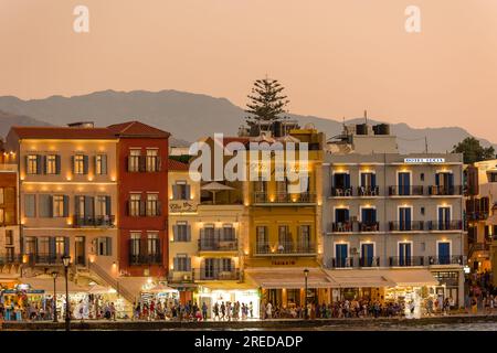 KRETA, GRIECHENLAND - JULI 03 2023: Abends treffen sich viele Touristen in Restaurants rund um den alten venezianischen Hafen von Chania im Westen Kretas Stockfoto