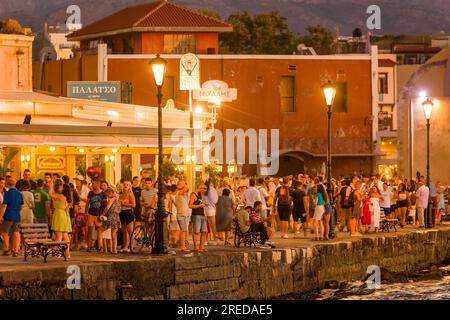 KRETA, GRIECHENLAND - JULI 03 2023: Abends treffen sich viele Touristen in Restaurants rund um den alten venezianischen Hafen von Chania im Westen Kretas Stockfoto